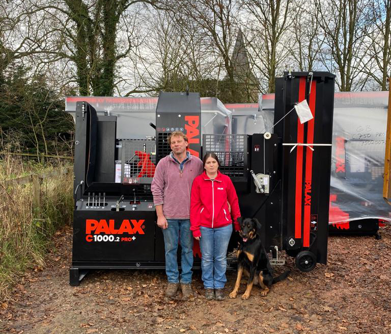 Edwin Rusling and Diana Lane with their dog next to a Palax C1000.2 Pro+ firewood processor.
