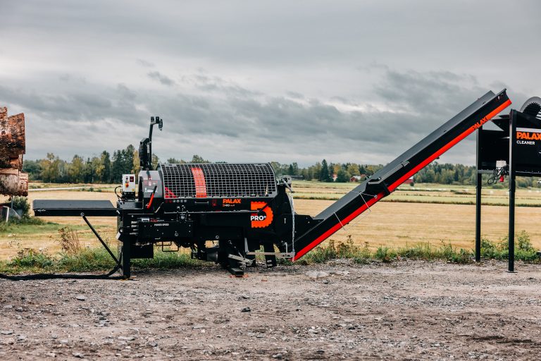 Palax D410 firewood processor next to a field.